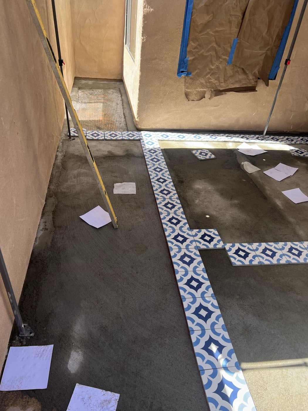 Patterned tile installation in progress on a patio
